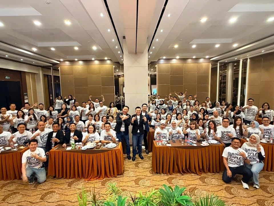Peserta kegiatan komunitas EVOLUTION berfoto bersama di ruang pertemuan dengan kaus seragam